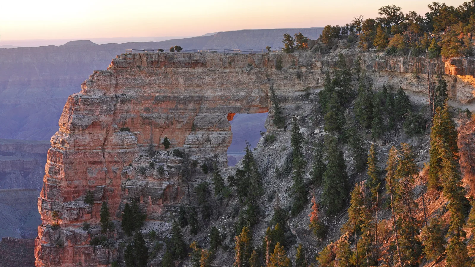 Angels Window cerca de Cape Royal al amanecer, un arco natural en el acantilado con una pasarela con barandal en la parte superior
